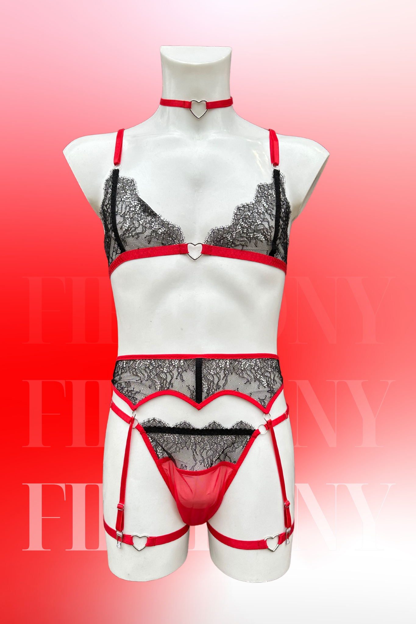 Front view of a red and black lace femboy lingerie set with heart details, featuring a bra, thong, garter belt, and choker on a male mannequin.