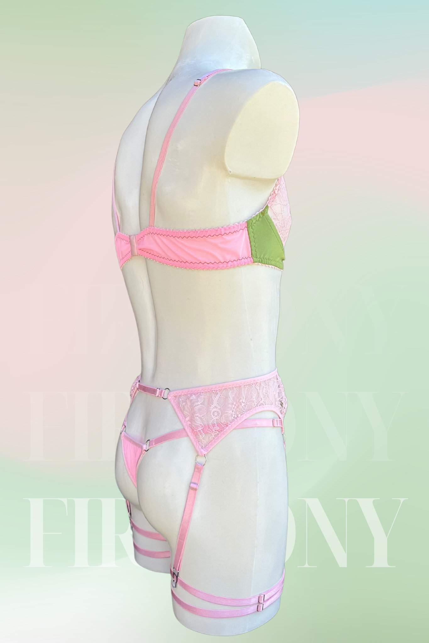 Angled back view of the men’s lace lingerie set in pastel colors with garter straps and thong.