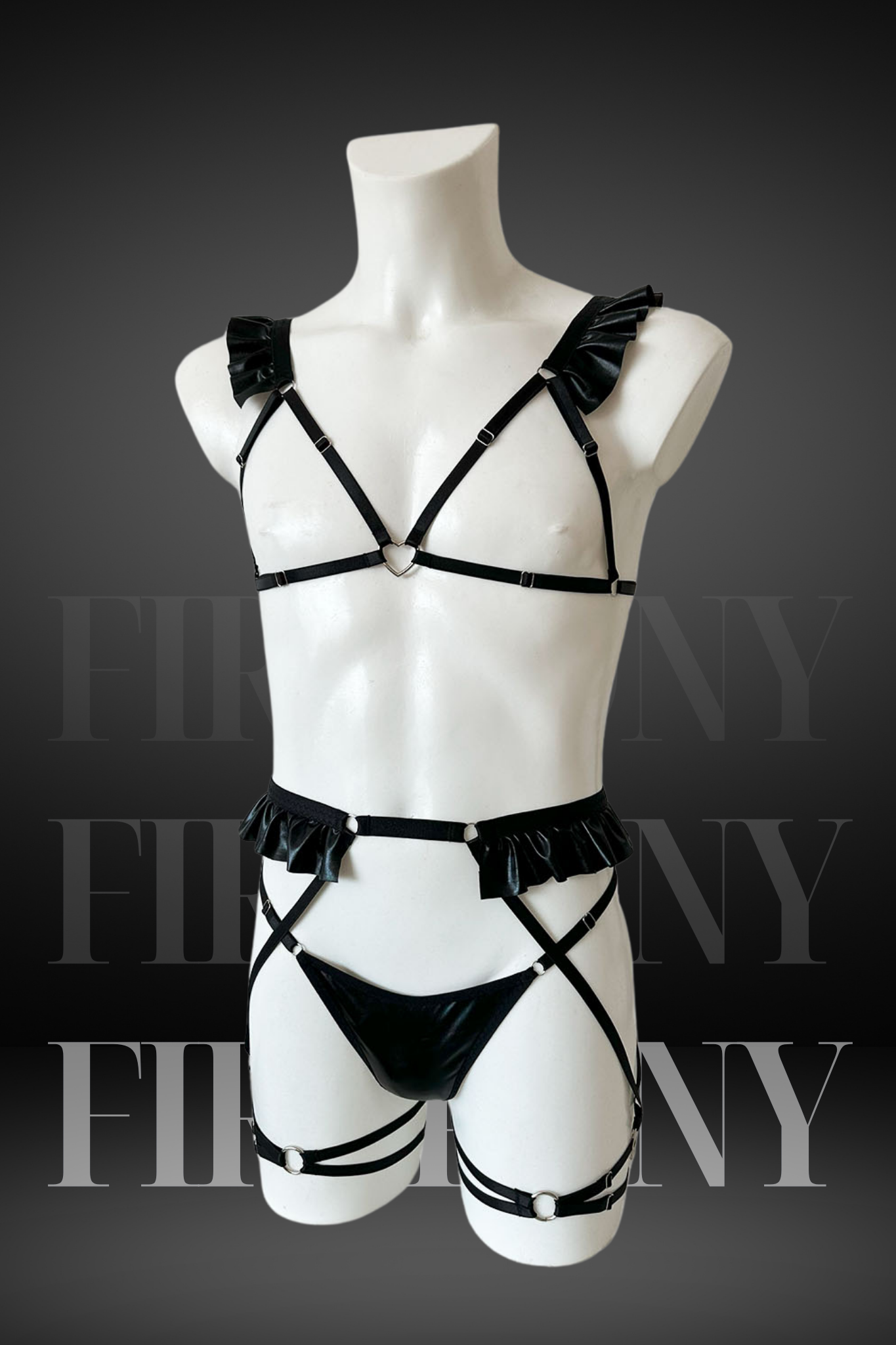 Full front view of black faux leather femboy lingerie with ruffles and heart ring