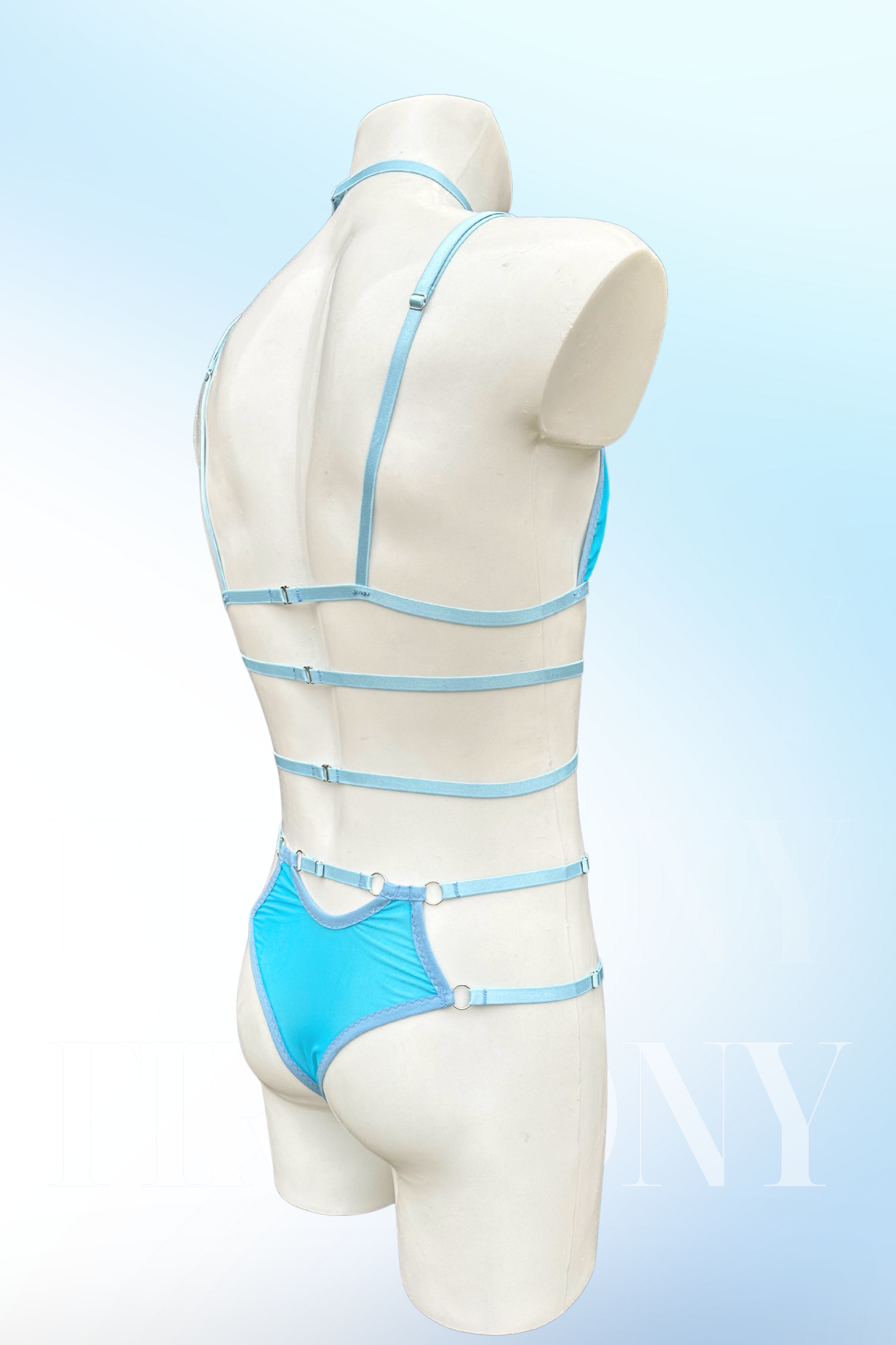 Angled back view of light blue strappy harness lingerie set for men.