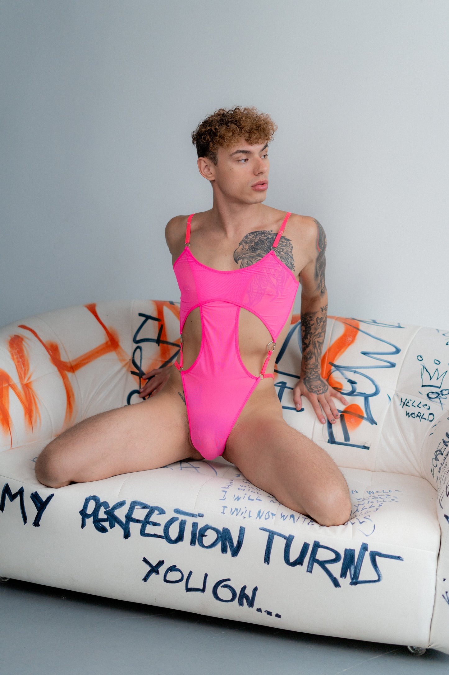 Model wearing pink mesh bodysuit with adjustable straps