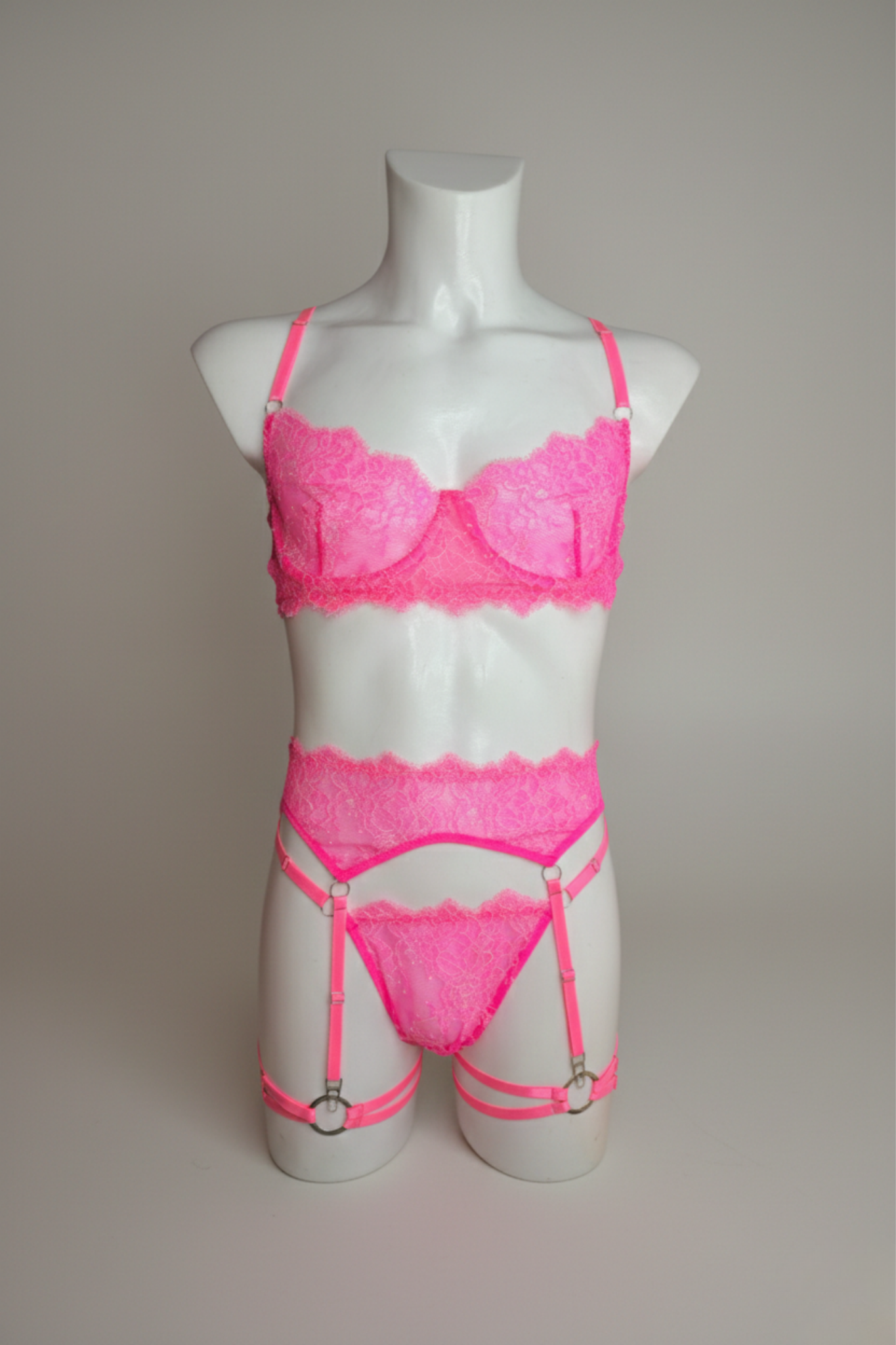 Мереживний неоново-рожевий комплект білизни: бюстгальтер, стрінги, пояс і підв’язки – регульовані бретелі