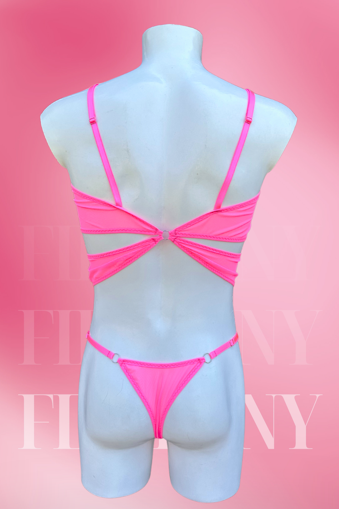 Back view of pink strappy bodysuit for men showing thong cut and adjustable straps