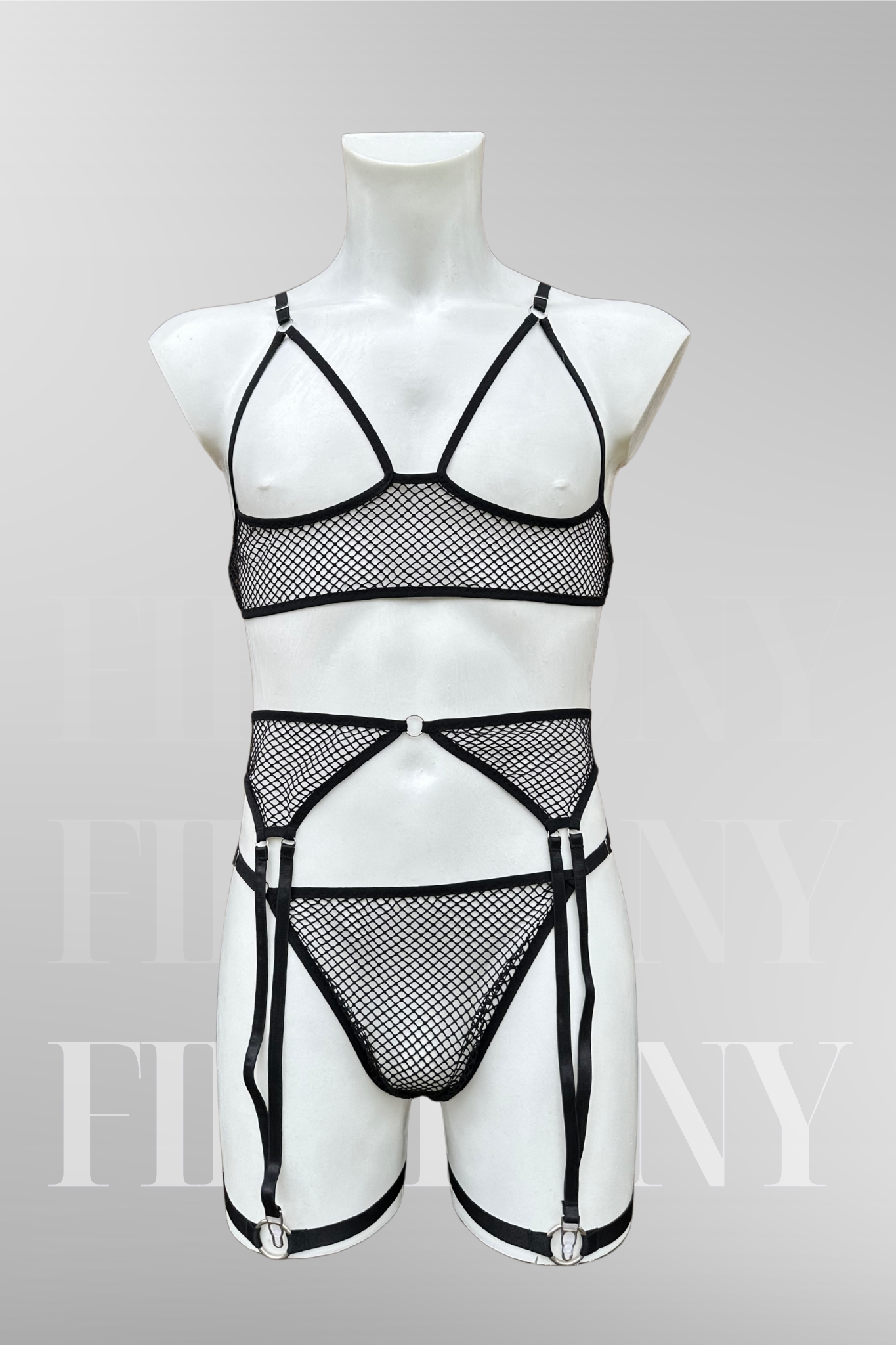 Side view of a black fishnet femboy lingerie set featuring a mesh bra, thong, and strappy garter belts on a male mannequin.