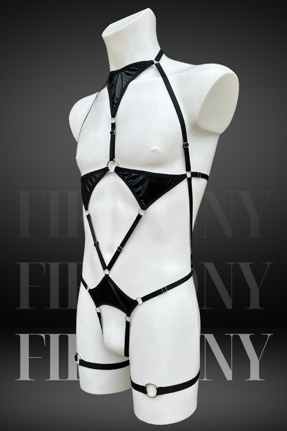 Side view of a black strappy wetlook bodysuit for men, showing metal rings and harness design.