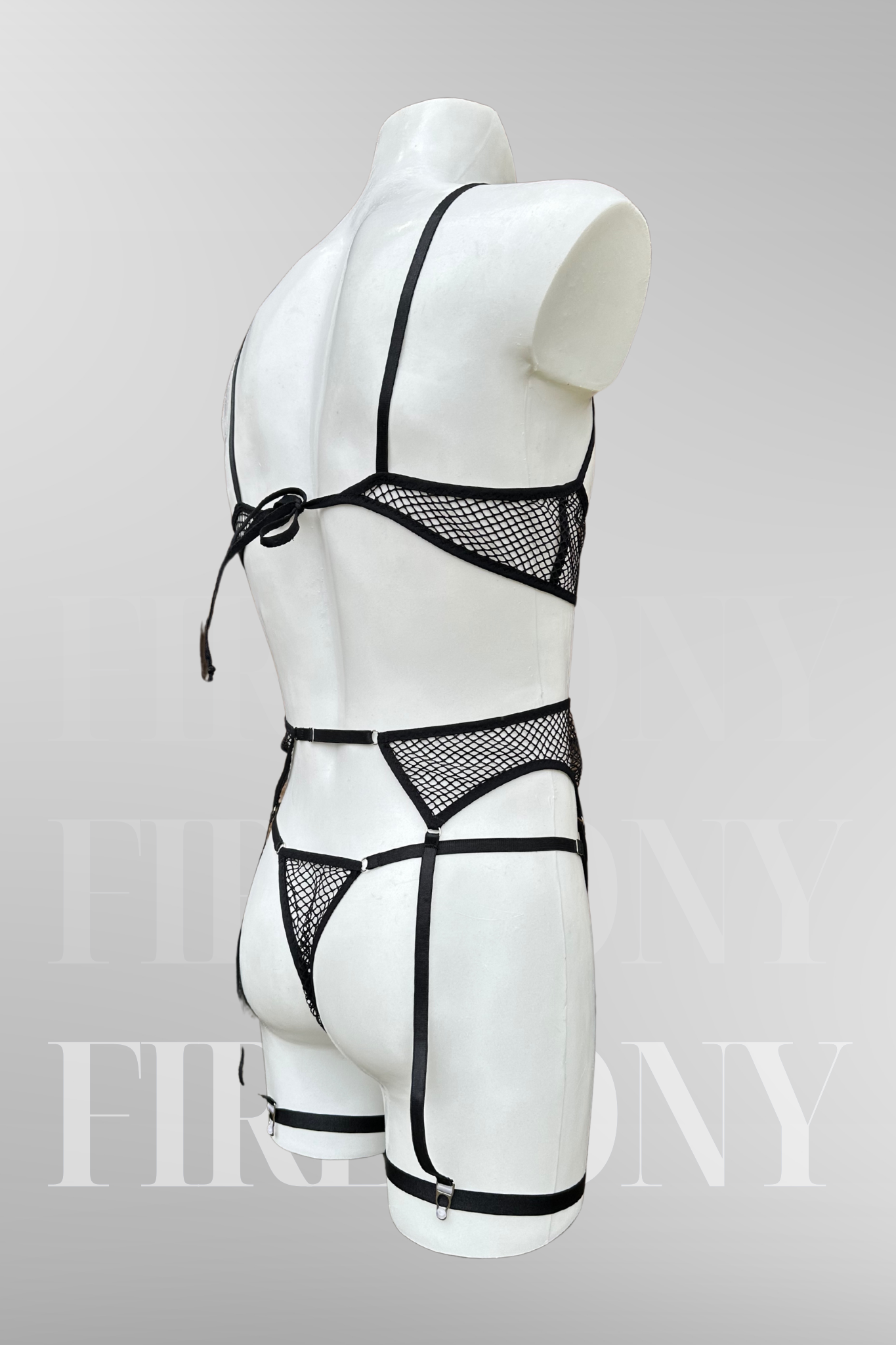  Back view of the set showing the tie-back bra, thong, and harness-style garters.