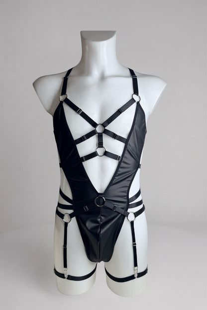 Men's vegan leather bodysuit with garter belt on mannequin, front view: deep V, O-ring waist strap and garter straps