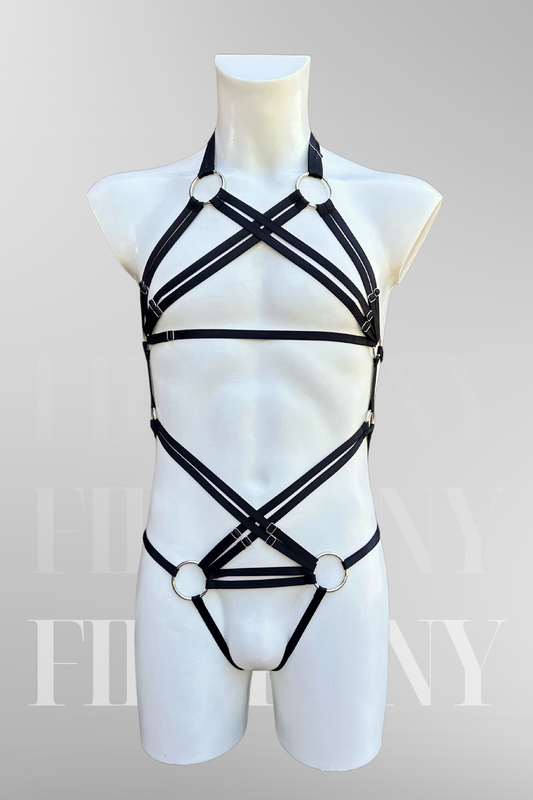 Front view of a black strappy body harness for men with O-rings and criss-cross chest design.