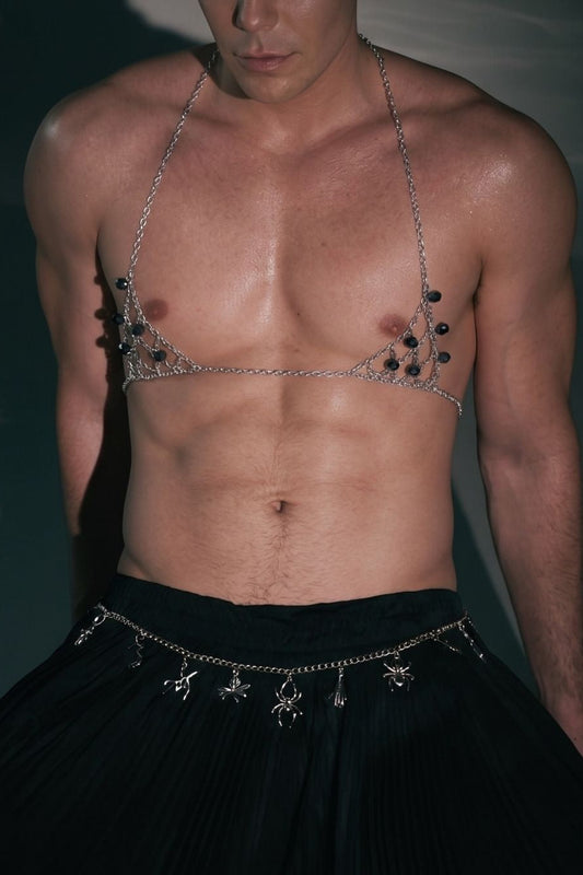 Man wearing Firepony silver chain body harness with black crystals in a dark studio setting.