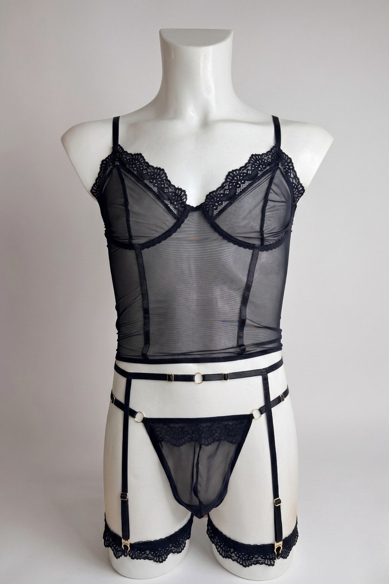 Black corset-style mesh top set for men on mannequin - lace trim top, thong and garter belt with gold hardware, front view