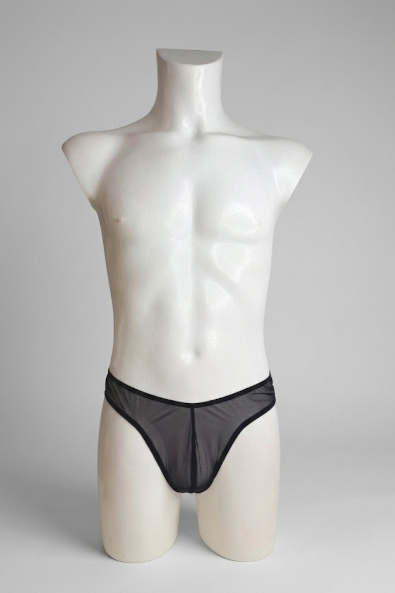 Sheer black mesh thong for men on mannequin - classic low-rise cut with slim waistband, front view