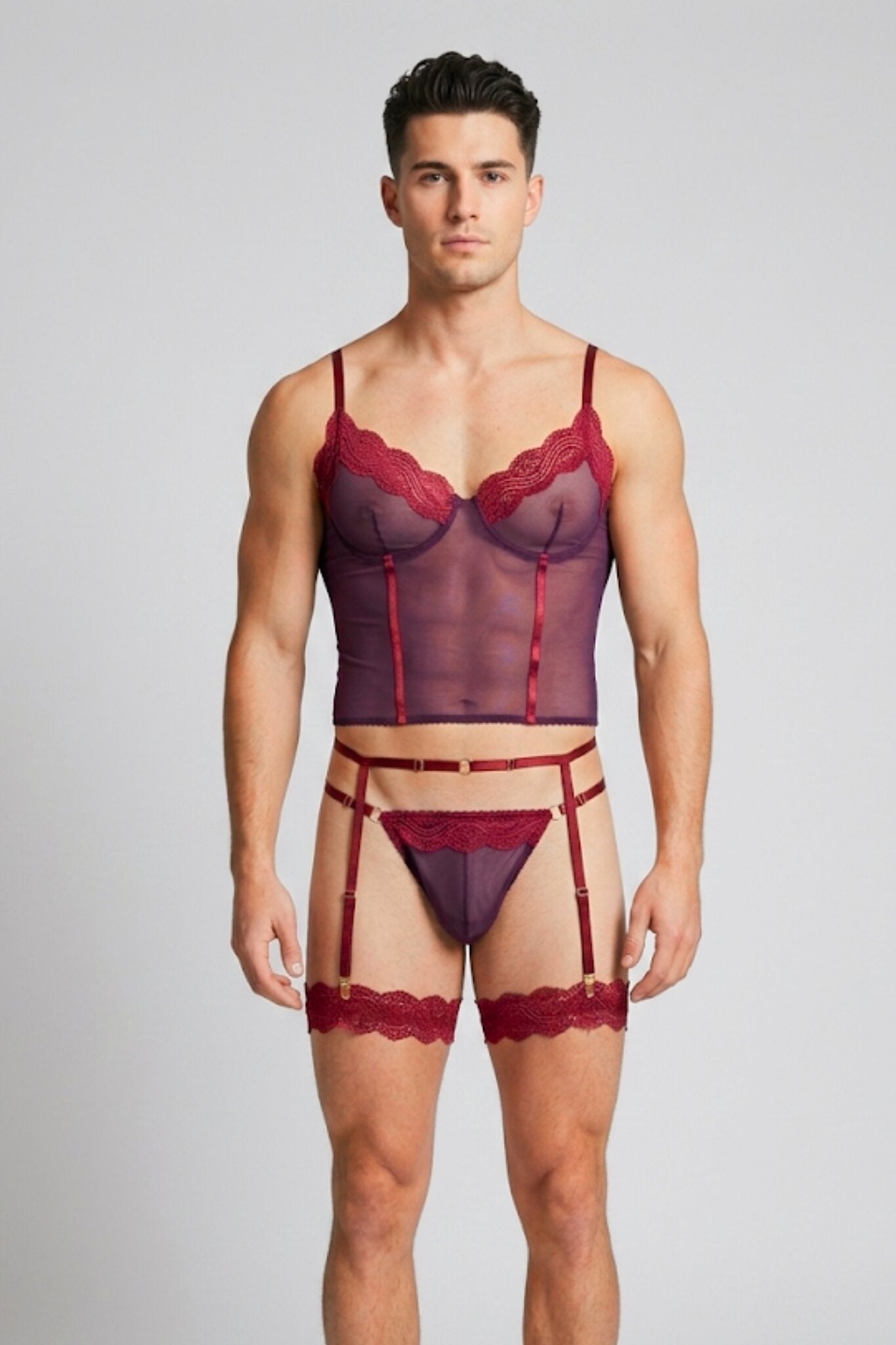 Man wearing burgundy mesh corset top lingerie set for men - sheer plum cami top with wine lace, thong, garter belt and lace leg garters by Fire Pony