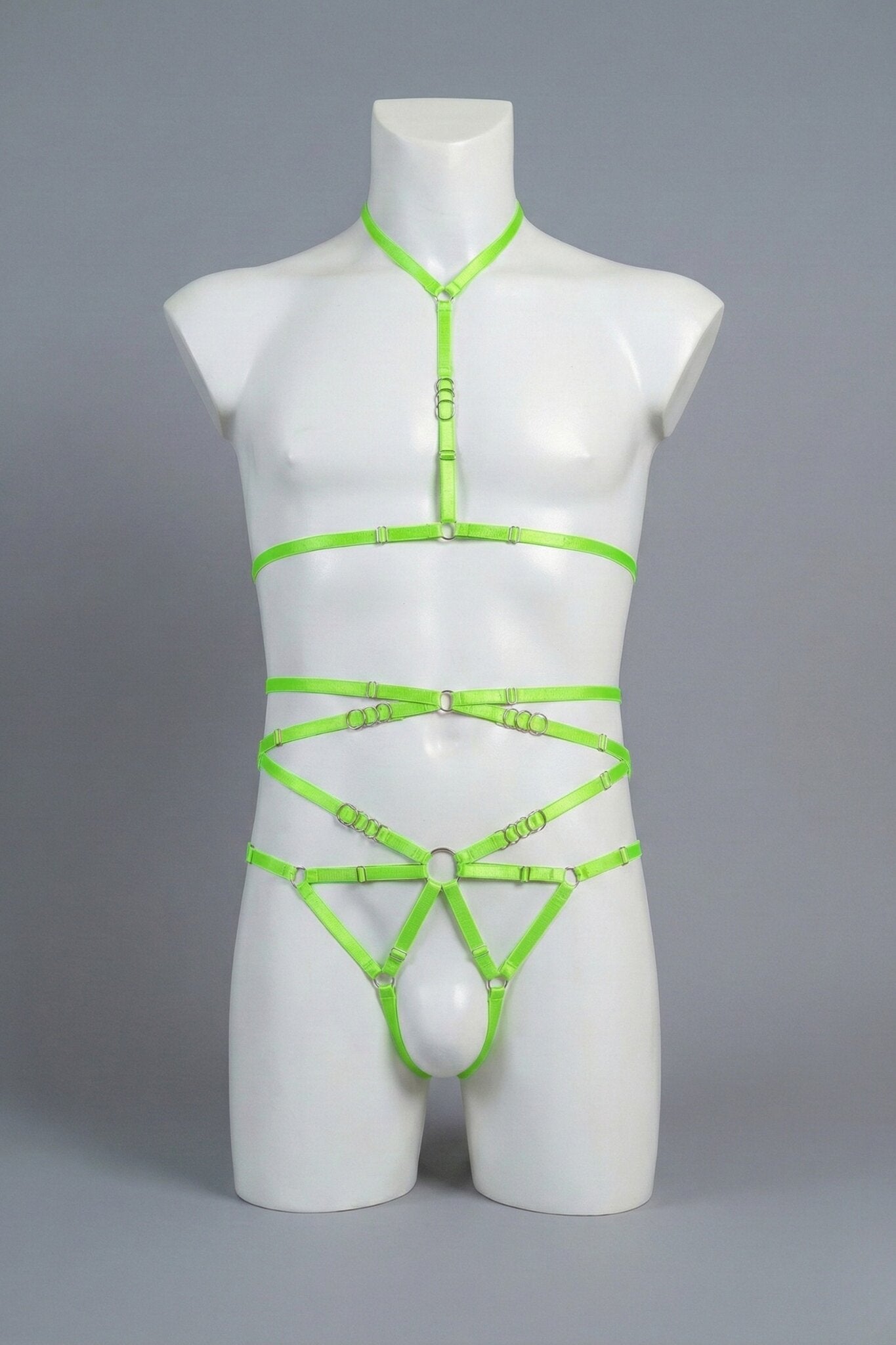 Neon green strappy body harness set for men on mannequin - choker harness top and open-frame harness bottom with silver o-rings, front view