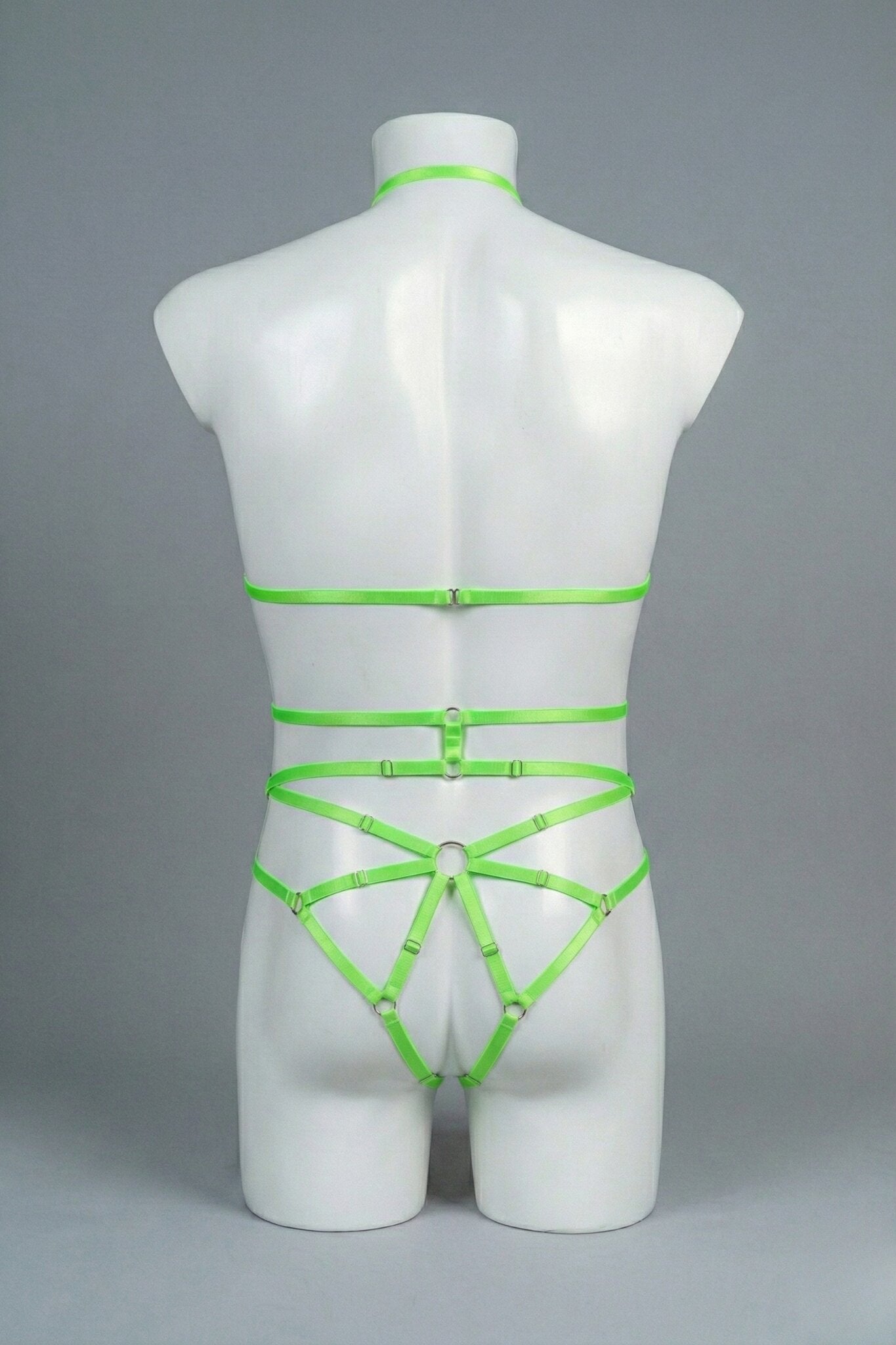 Back view of men's neon green strappy body harness set - crossing waist straps and open-frame back with o-rings