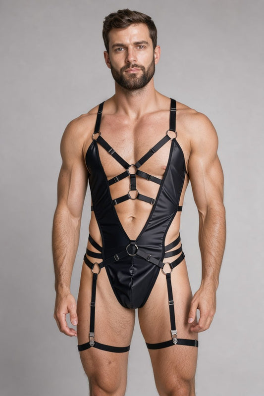 Black vegan leather harness bodysuit with garter belt on a male model: deep V front, O-ring straps and thigh bands