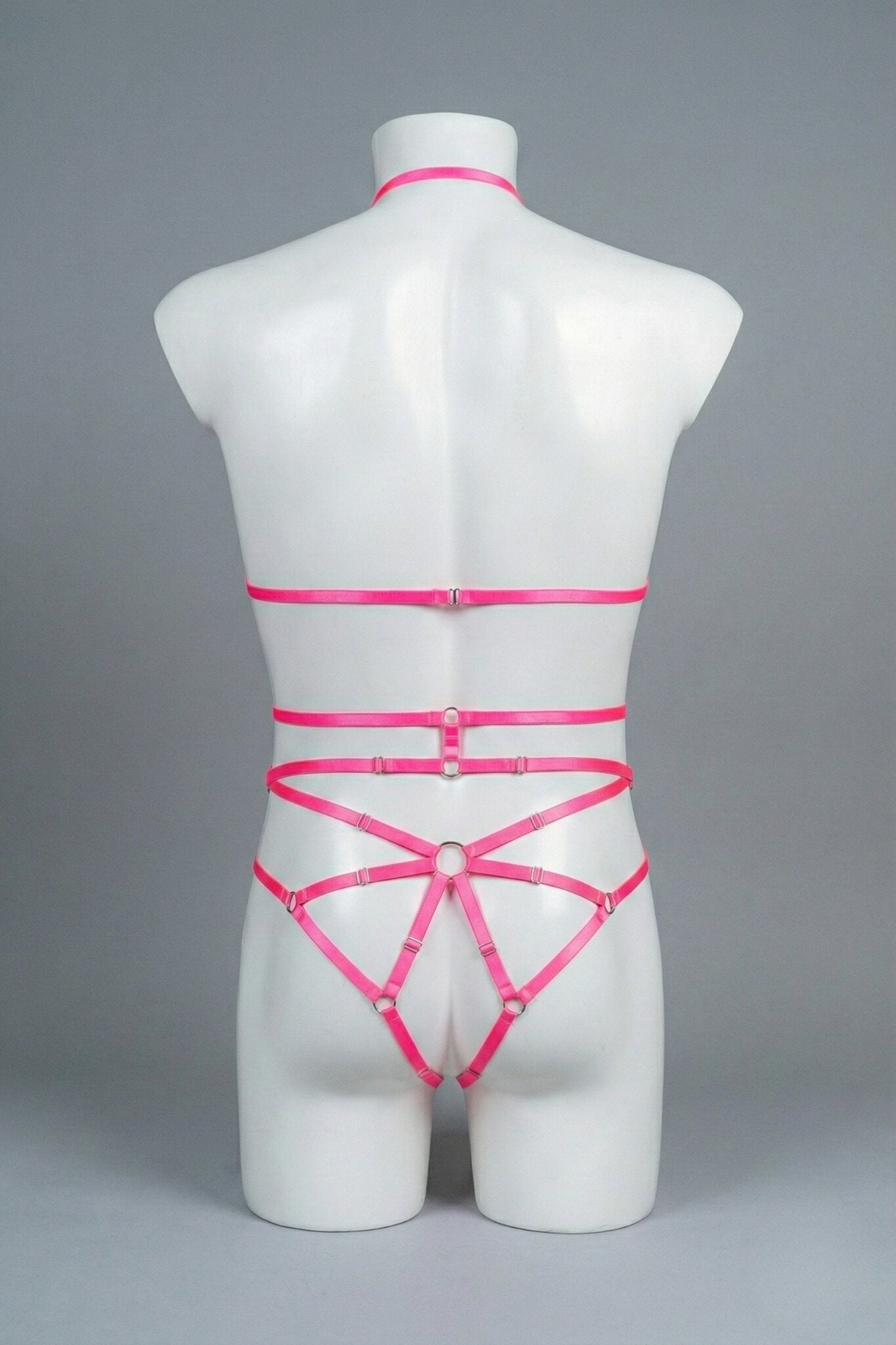 Back view of men's pink strappy body harness set - crossing waist straps and open-frame back with o-rings