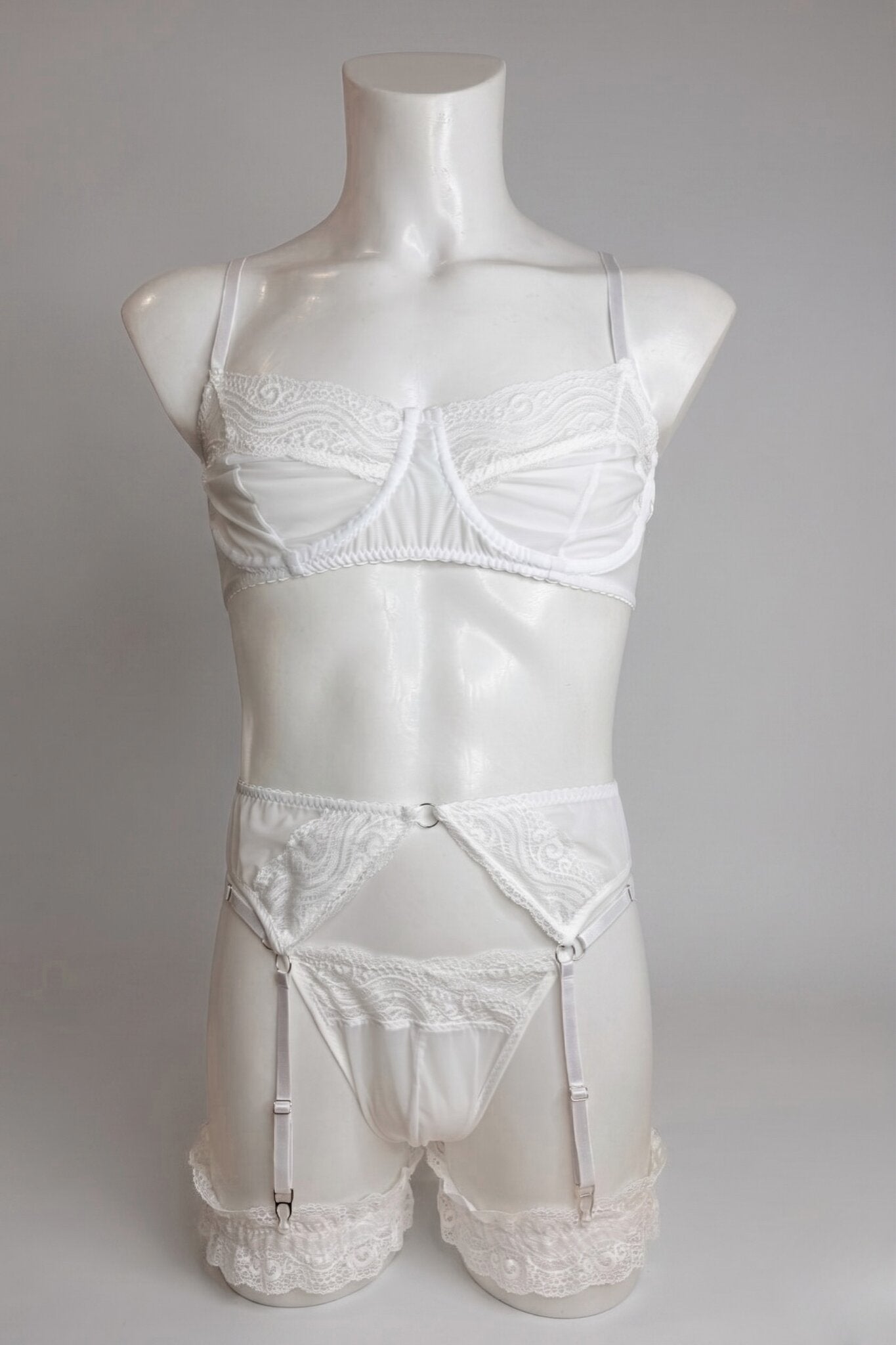White lace lingerie set for men on mannequin - sheer bra, thong, garter belt and lace leg garters, front view