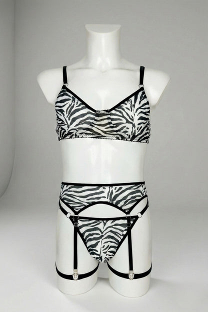 Zebra print mesh lingerie set for men on mannequin - sheer bra, thong and garter belt with silver hardware, front view
